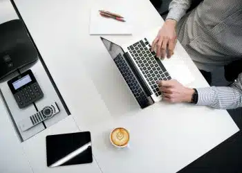 person using laptop on white wooden table