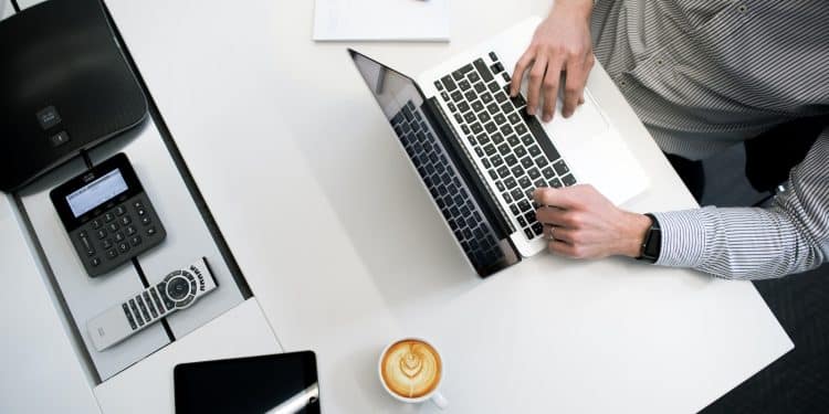 person using laptop on white wooden table