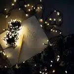 photo of string lights on open book beside pencil